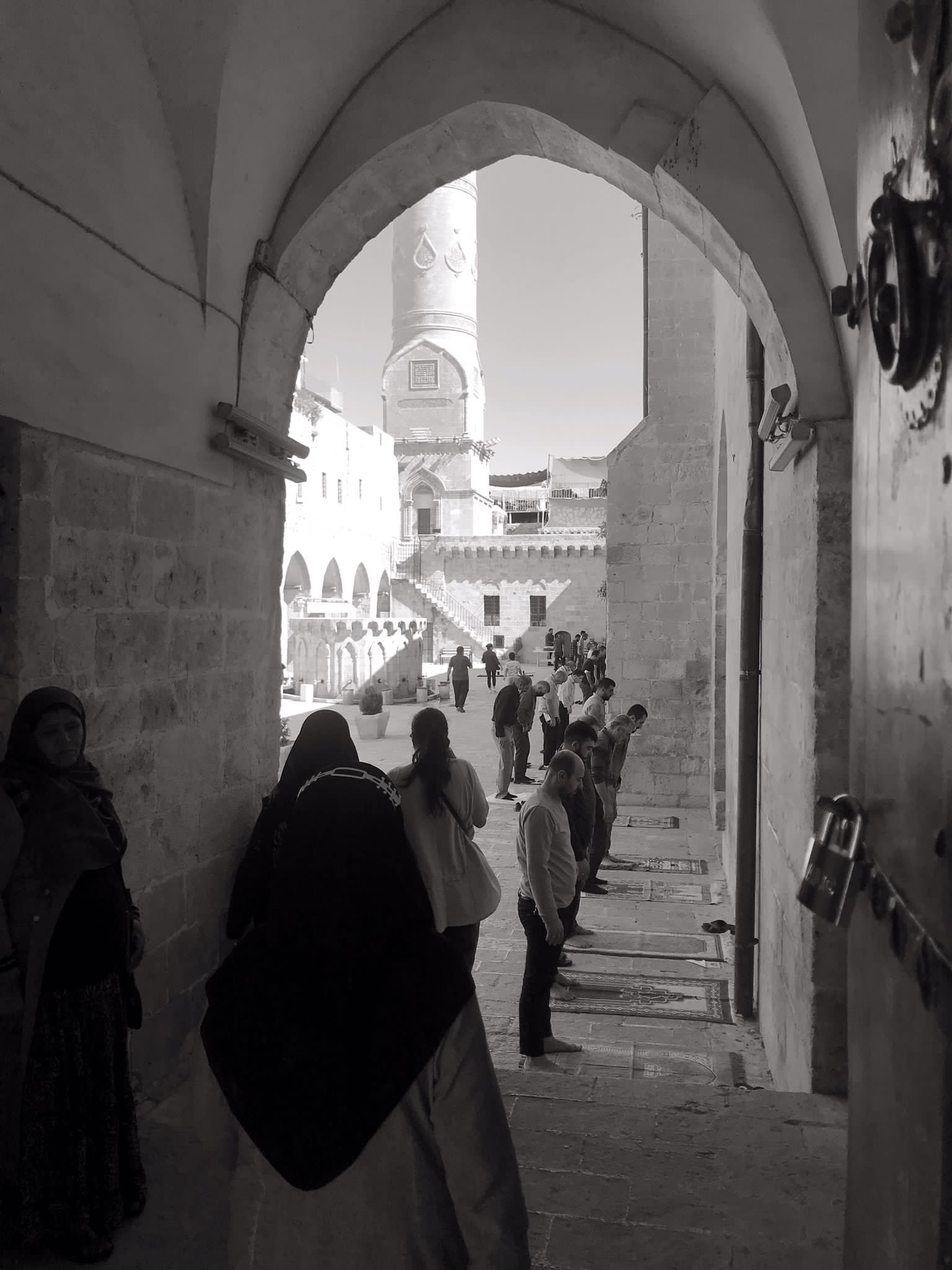Taş kemerin altından avluya açılan siyah beyaz arşiv karesi